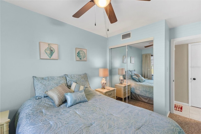 bedroom featuring a ceiling fan, a closet, visible vents, and carpet flooring