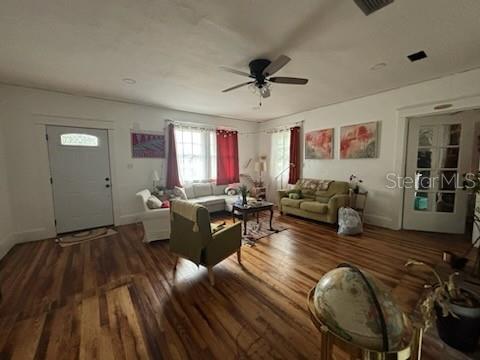 living area with ceiling fan, baseboards, and wood finished floors