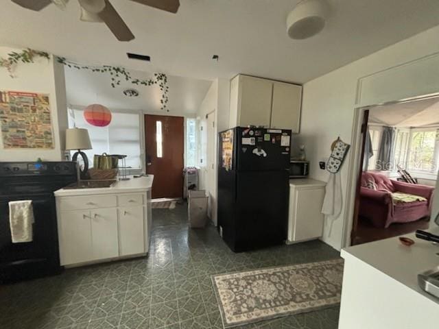 kitchen with ceiling fan, black appliances, light countertops, and white cabinetry