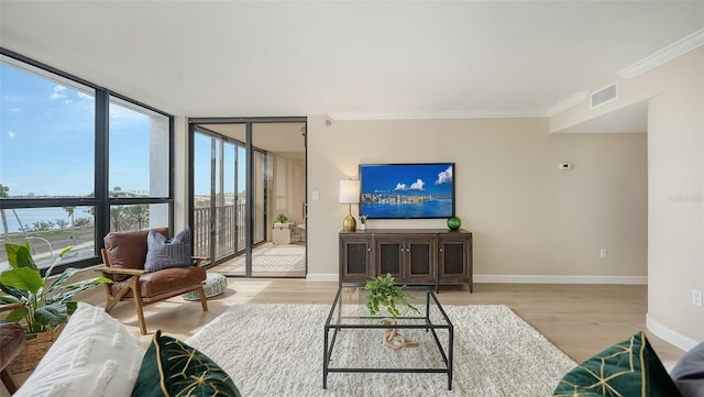 living room featuring floor to ceiling windows, crown molding, visible vents, wood finished floors, and baseboards