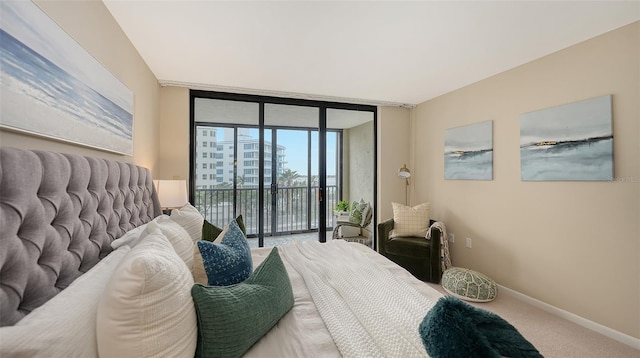 carpeted bedroom with access to outside, a wall of windows, and baseboards