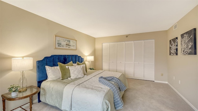 carpeted bedroom with a closet, visible vents, and baseboards