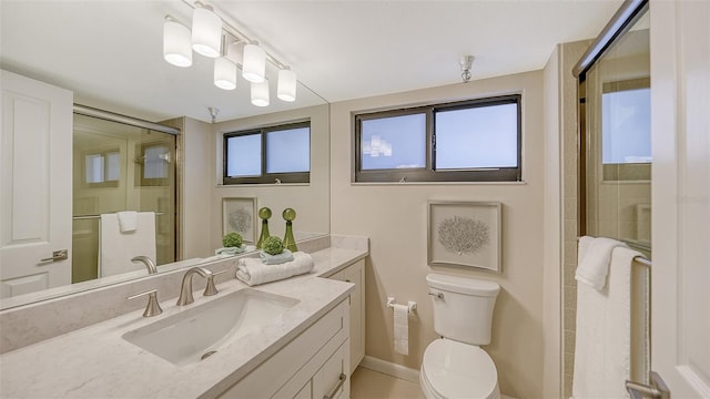 bathroom with toilet, a shower stall, a wealth of natural light, and vanity