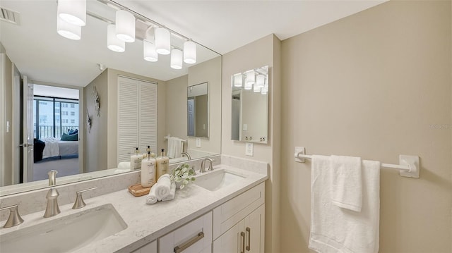 bathroom with double vanity, visible vents, and a sink