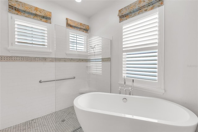 bathroom with tiled shower and a freestanding bath