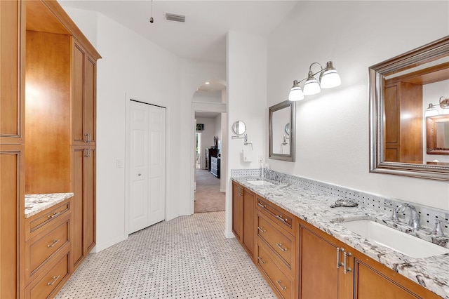 bathroom featuring double vanity, visible vents, and a sink