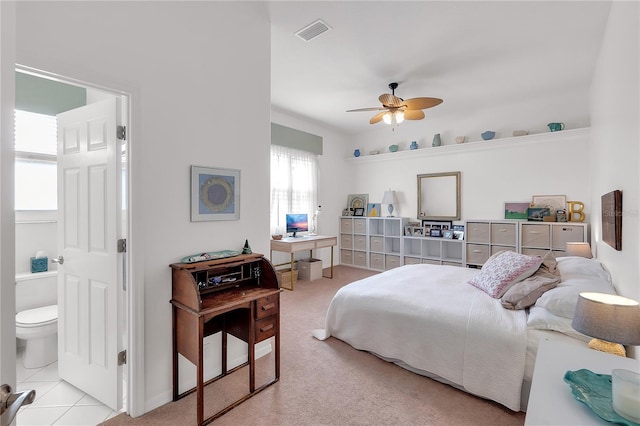 bedroom with ensuite bath, visible vents, a ceiling fan, and carpet