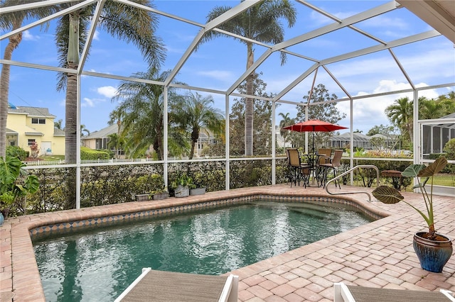 pool with glass enclosure and a patio