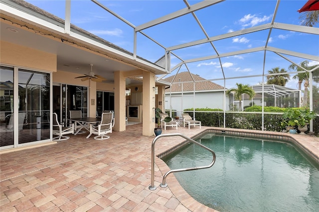 outdoor pool with a patio, a lanai, and ceiling fan