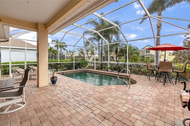 pool with glass enclosure and a patio area