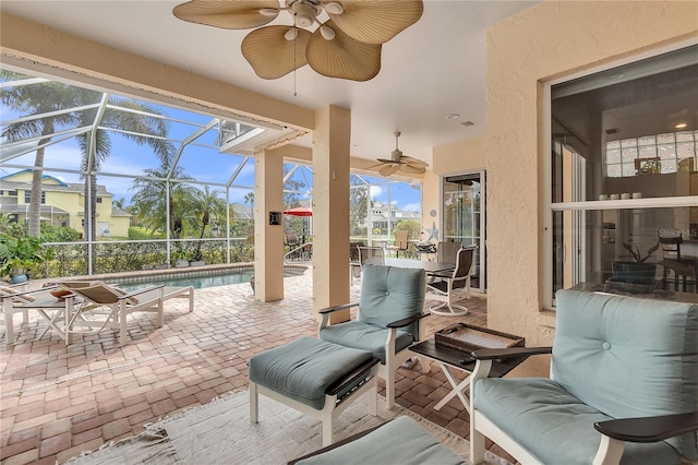 view of patio / terrace with a lanai, an outdoor pool, and ceiling fan