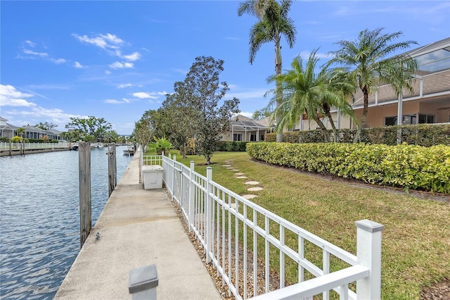 dock area with a yard and a water view