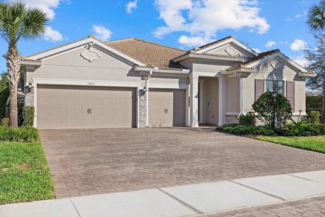 single story home with a garage, stone siding, and stucco siding