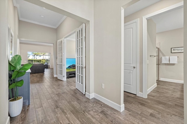 hallway with crown molding, french doors, wood finished floors, and baseboards