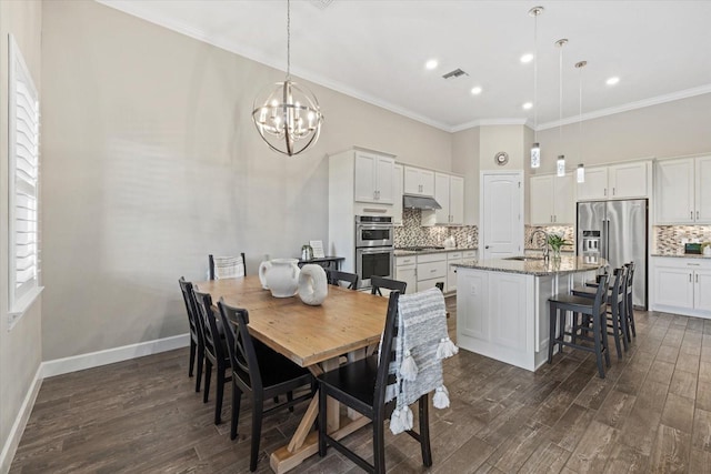 dining room featuring baseboards, dark wood finished floors, and crown molding