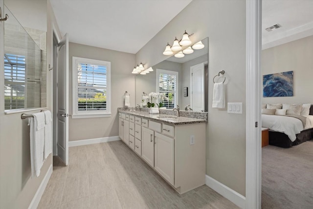 full bathroom with double vanity, a sink, and baseboards