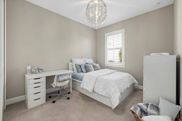 bedroom with an inviting chandelier, baseboards, and light colored carpet