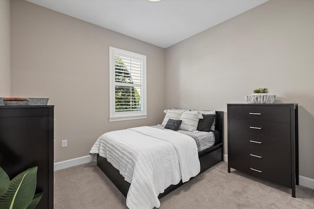 bedroom with light carpet and baseboards