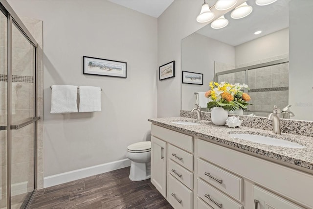 bathroom with wood finished floors, a sink, and a shower stall