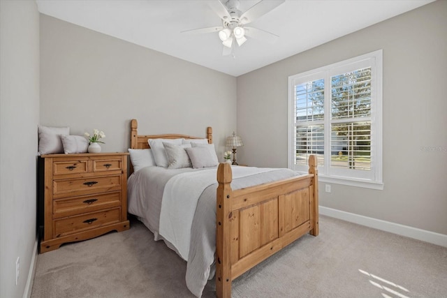 bedroom with light carpet, a ceiling fan, and baseboards