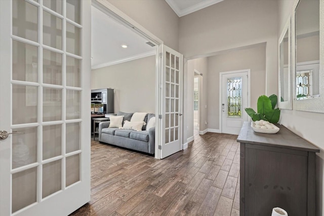 interior space featuring dark wood-style floors, french doors, a towering ceiling, ornamental molding, and baseboards