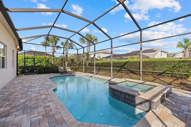 view of swimming pool with glass enclosure, a pool with connected hot tub, and a patio