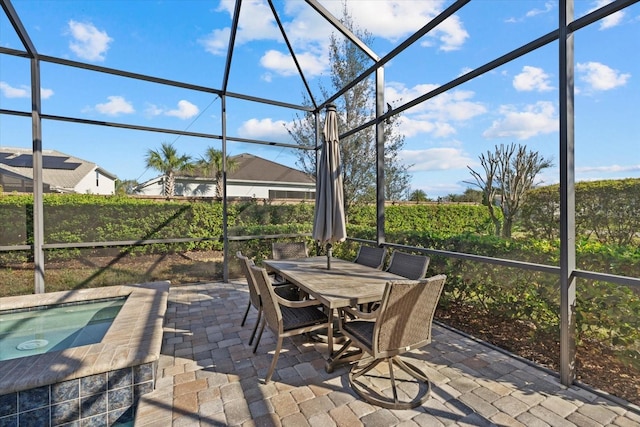 view of patio / terrace featuring an in ground hot tub, outdoor dining space, and a lanai