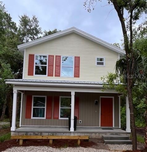 view of front of home featuring board and batten siding, covered porch, and metal roof