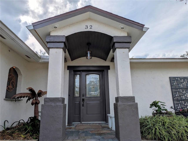 doorway to property featuring stucco siding