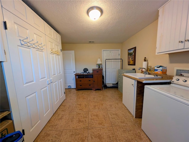 32 Fallen Oak Ln, Palm Coast, FL 32137 - laundry area featuring washer / clothes dryer, cabinet space, a textured ceiling, and light tile patterned flooring
