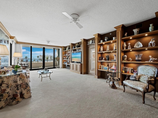 sitting room featuring a ceiling fan, carpet flooring, and a textured ceiling