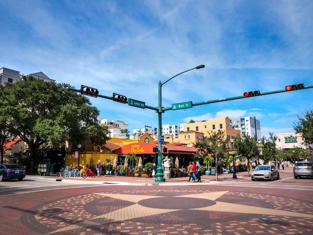 view of street featuring street lights, curbs, traffic lights, and sidewalks