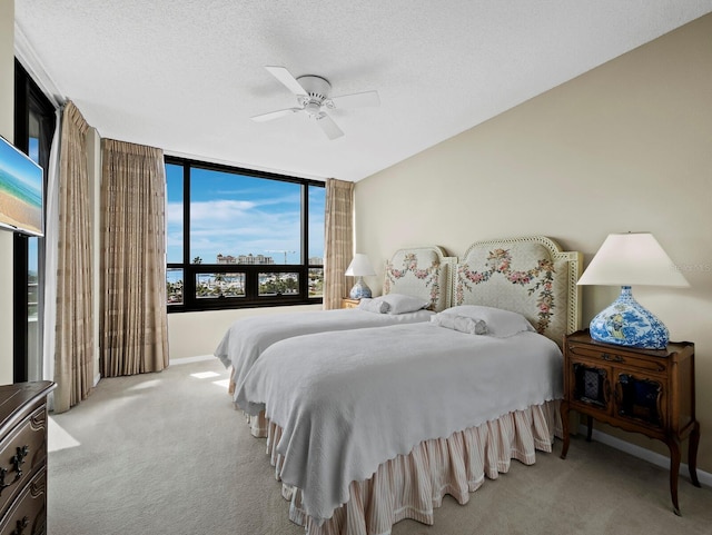 carpeted bedroom with ceiling fan, baseboards, and a textured ceiling