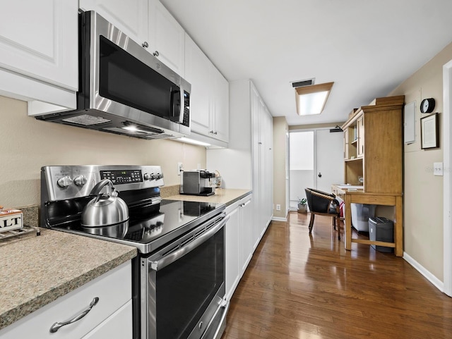kitchen featuring appliances with stainless steel finishes, dark wood-type flooring, light countertops, and white cabinetry