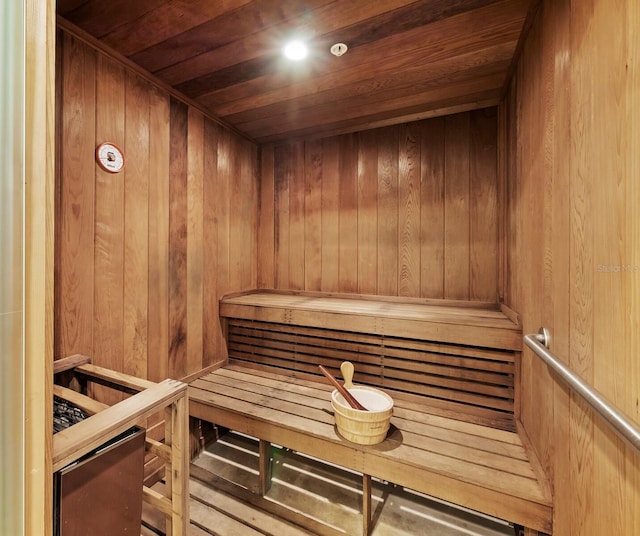sauna / steam room with wooden ceiling and wood walls
