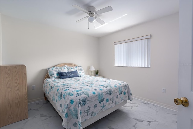 bedroom featuring ceiling fan, marble finish floor, and baseboards