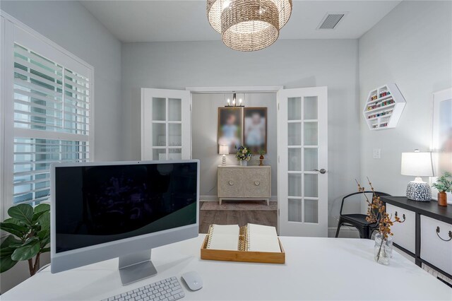 interior space with visible vents, a notable chandelier, and french doors