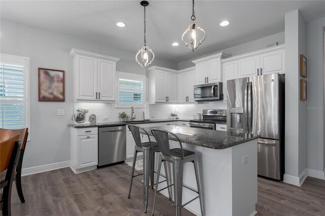 kitchen featuring white cabinetry, dark wood-type flooring, backsplash, and appliances with stainless steel finishes