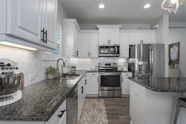 kitchen featuring a sink, stainless steel appliances, dark wood-style floors, and white cabinetry