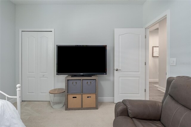 carpeted bedroom featuring a closet and baseboards