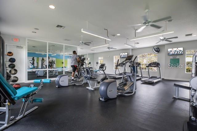 workout area featuring visible vents, baseboards, and ceiling fan