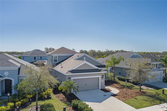 view of front of home featuring a residential view, concrete driveway, a garage, and a shingled roof