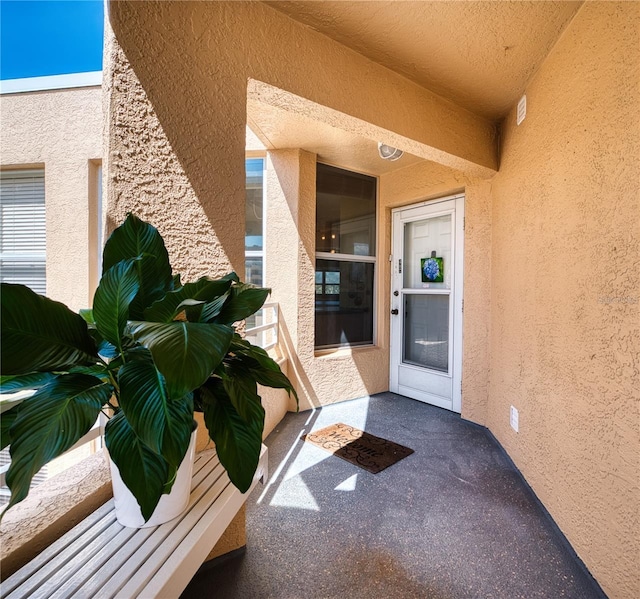 entrance to property featuring stucco siding