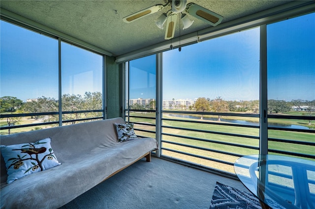 unfurnished sunroom with a water view and ceiling fan