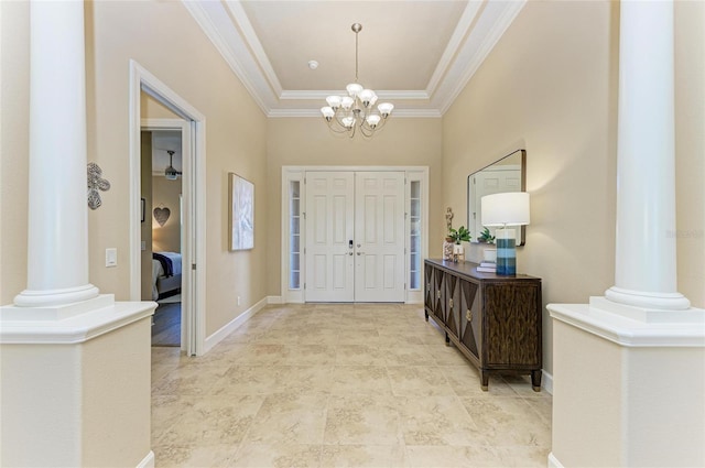 foyer with ornamental molding, decorative columns, baseboards, and an inviting chandelier