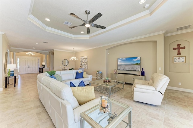 living room with baseboards, visible vents, a tray ceiling, and crown molding