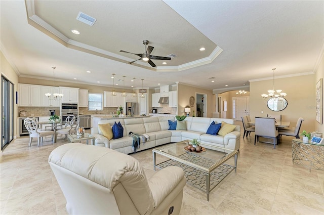 living room featuring ceiling fan with notable chandelier, a raised ceiling, visible vents, and recessed lighting