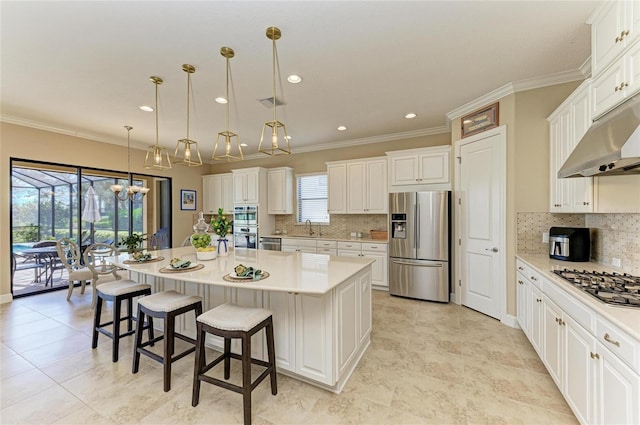 kitchen featuring a kitchen island, ornamental molding, stainless steel appliances, light countertops, and a sink