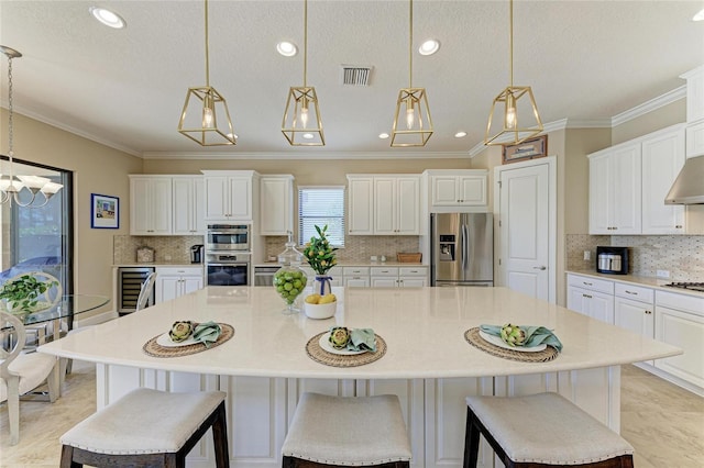 kitchen featuring visible vents, white cabinets, a large island, wine cooler, and appliances with stainless steel finishes