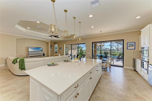 kitchen with visible vents, white cabinets, and crown molding